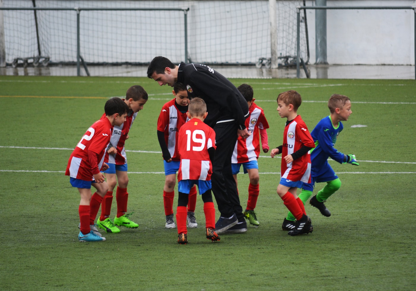 Coach huddled with youth sports team on game day